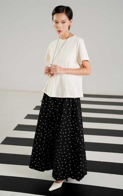 Atasan wanita Fernandez Top warna Ivory dengan detail jahitan vertikal terstruktur di bagian depan, kerah bulat, dan lengan pendek dari This Is April. 