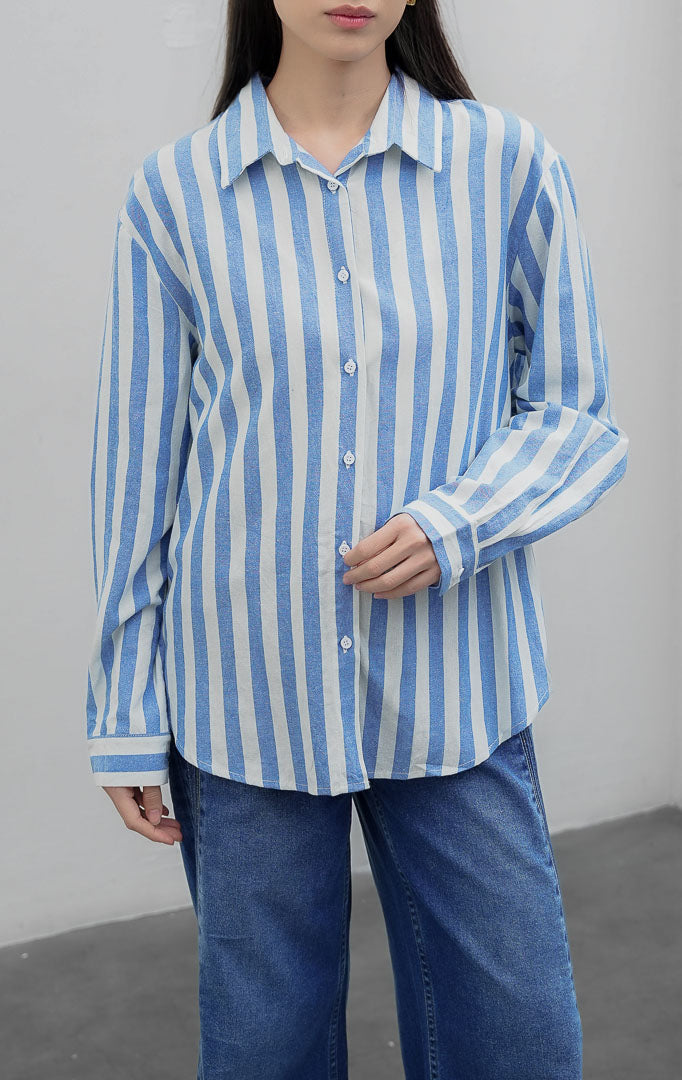 Kemeja wanita lengan panjang bahan katun linen (cotton linen) Ferzetti Top dengan motif garis salur vertikal (awning stripe) warna biru (blue) dan putih, kerah kemeja, serta bukaan kancing depan.