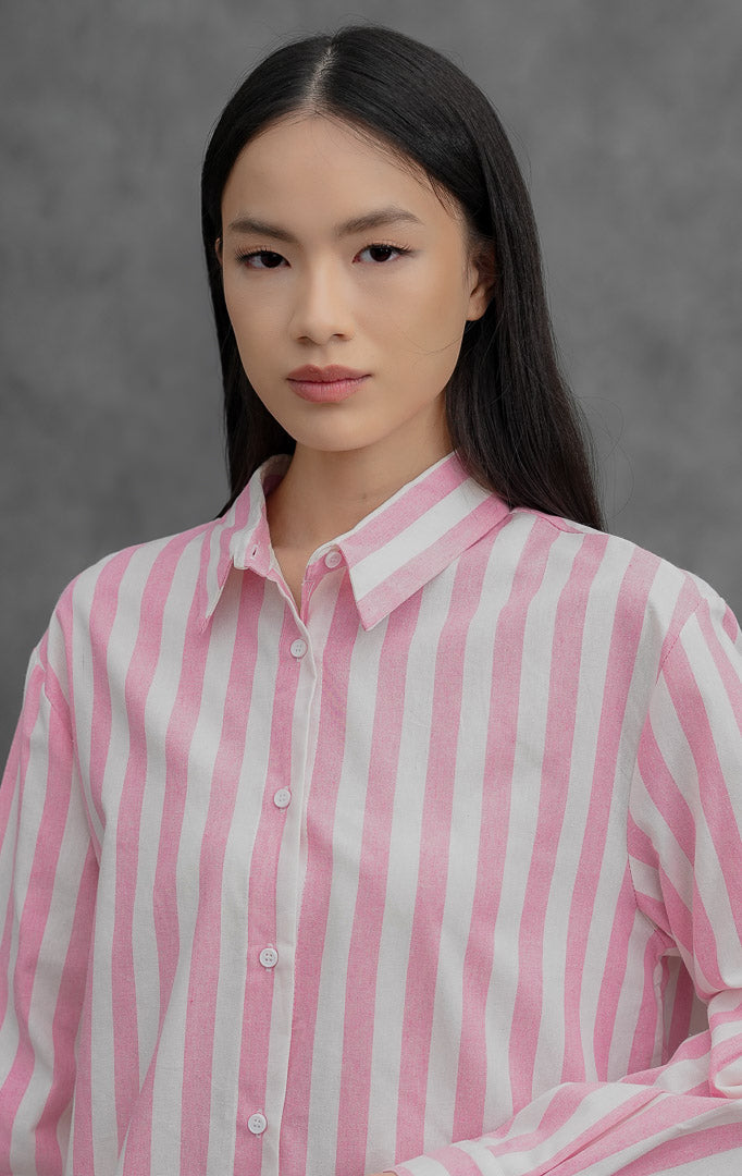 Kemeja wanita lengan panjang bahan katun linen (cotton linen) Ferzetti Top dengan motif garis salur vertikal (awning stripe) warna merah muda (pink) dan putih, kerah kemeja, serta bukaan kancing depan.
