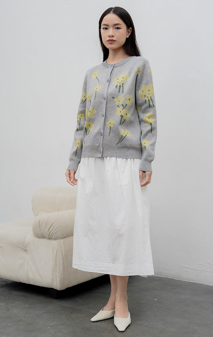 Sweter rajut wanita lengan panjang warna abu-abu (grey) Fleur Sweater dengan motif bunga kuning (floral print), kerah bulat (crew neck), dan kancing depan.