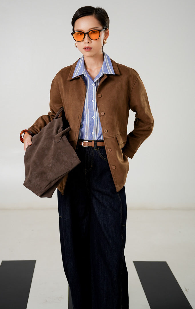 Jaket suede wanita Frances Jacket warna Brown dengan detail kerah, kancing depan senada, saku dengan tutup (flap pockets), dan material suede bertekstur lembut dari This Is April. 