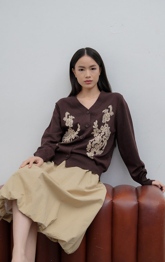 Kardigan rajut wanita lengan panjang warna cokelat tua (dark brown) Franklynn Cardigan dengan kerah V (V-neck), bukaan kancing depan, dan aksen bordir bunga tekstur timbul (floral tactile wave).