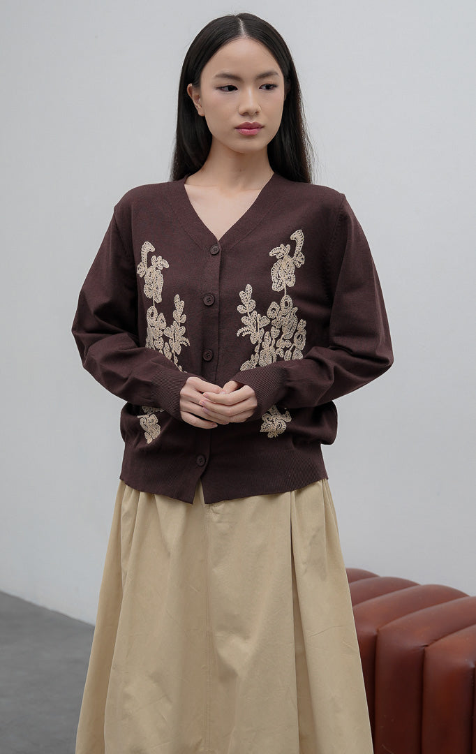 Kardigan rajut wanita lengan panjang warna cokelat tua (dark brown) Franklynn Cardigan dengan kerah V (V-neck), bukaan kancing depan, dan aksen bordir bunga tekstur timbul (floral tactile wave).
