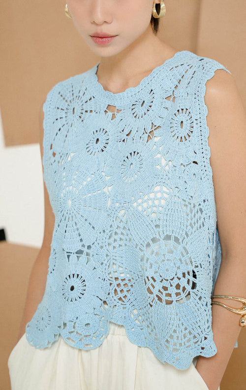 Close up model mengenakan Garvella Sleeveless Floral Crochet Top Light Blue, produk atasan rajut tanpa lengan wanita motif bunga dengan detail open-knit transparan. 