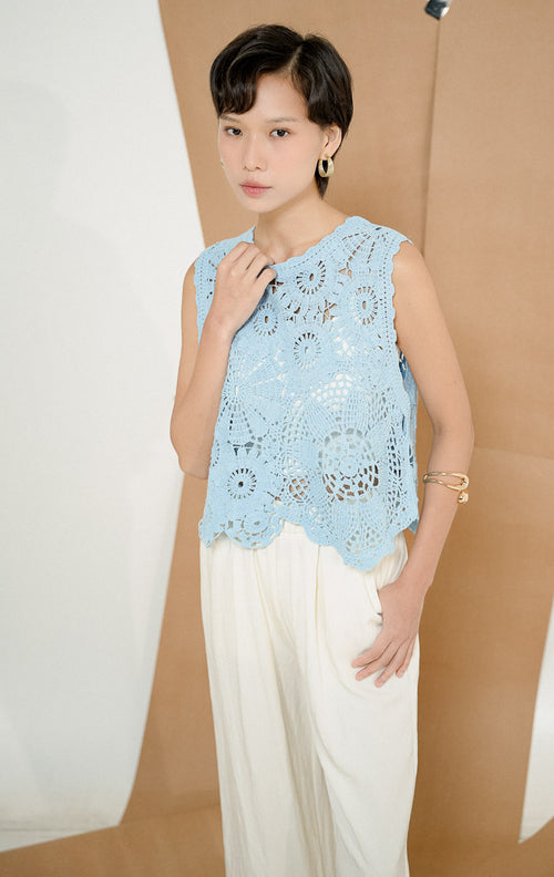 Close up model mengenakan Garvella Sleeveless Floral Crochet Top Light Blue, produk atasan rajut tanpa lengan wanita motif bunga dengan detail open-knit transparan. 