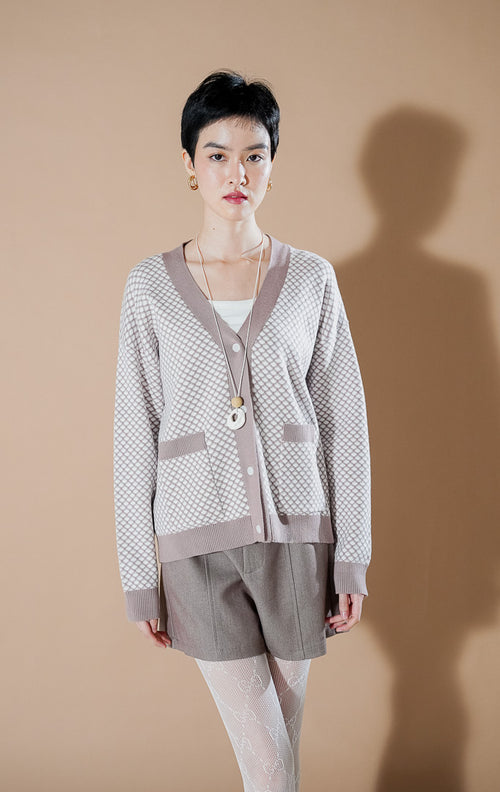the Gilda brown patterned knit cardigan featuring a V-neck, button-down front, and pockets, styled with casual shorts.