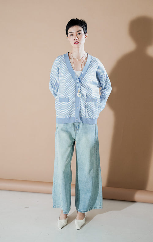 Model wanita mengenakan Gilda Patterned Knit Cardigan warna Blue, kardigan rajut v-neck dengan motif ketupat kecil (diamond pattern) dan saku depan dari This Is April.