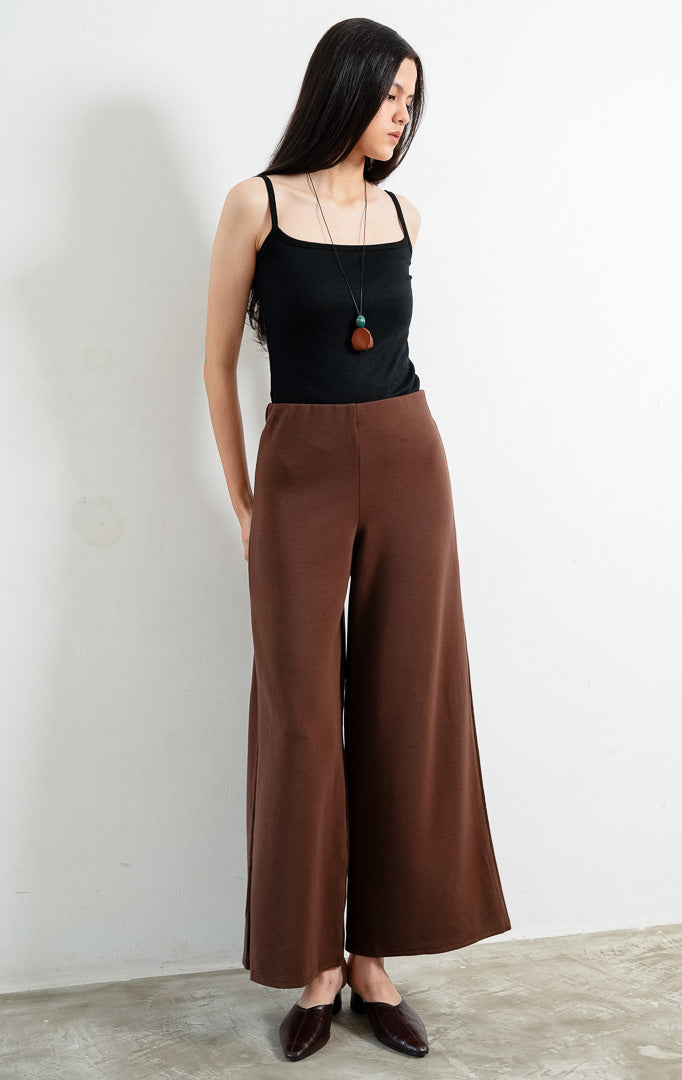 Celana panjang wanita warna cokelat tua (dark brown long pants) Hadrian Pants dengan siluet lurus (straight-leg silhouette), konstruksi bahan rajut rib bertekstur (textured rib knit construction), dan ban pinggang fleksibel (flexible waistband). 