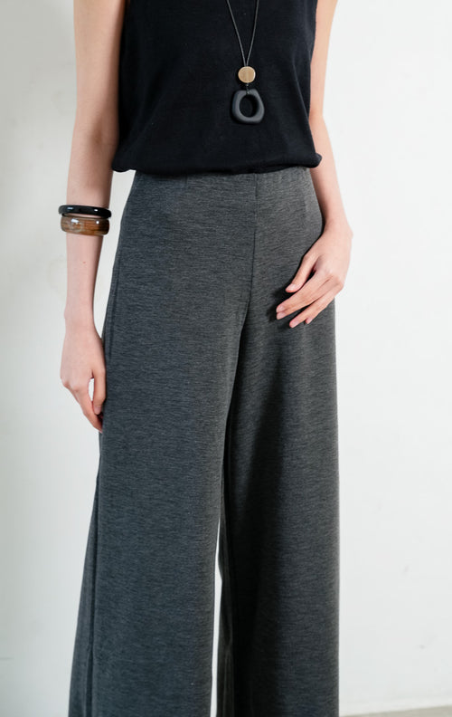 Celana panjang wanita warna abu-abu tua (dark grey long pants) Hadrian Pants dengan siluet lurus (straight-leg silhouette), konstruksi bahan rajut rib bertekstur (textured rib knit construction), dan ban pinggang fleksibel (flexible waistband). 