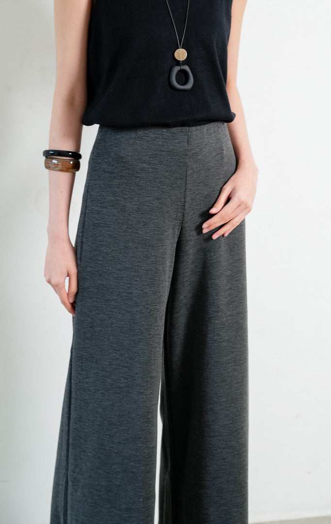 Celana panjang wanita warna abu-abu tua (dark grey long pants) Hadrian Pants dengan siluet lurus (straight-leg silhouette), konstruksi bahan rajut rib bertekstur (textured rib knit construction), dan ban pinggang fleksibel (flexible waistband). 