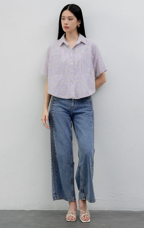 Kemeja katun wanita lengan pendek potongan boxy warna merah muda (pink) Hampton Top berkerah (spread collar) dengan motif garis vertikal (striped pattern), kancing depan, dan saku dada.
