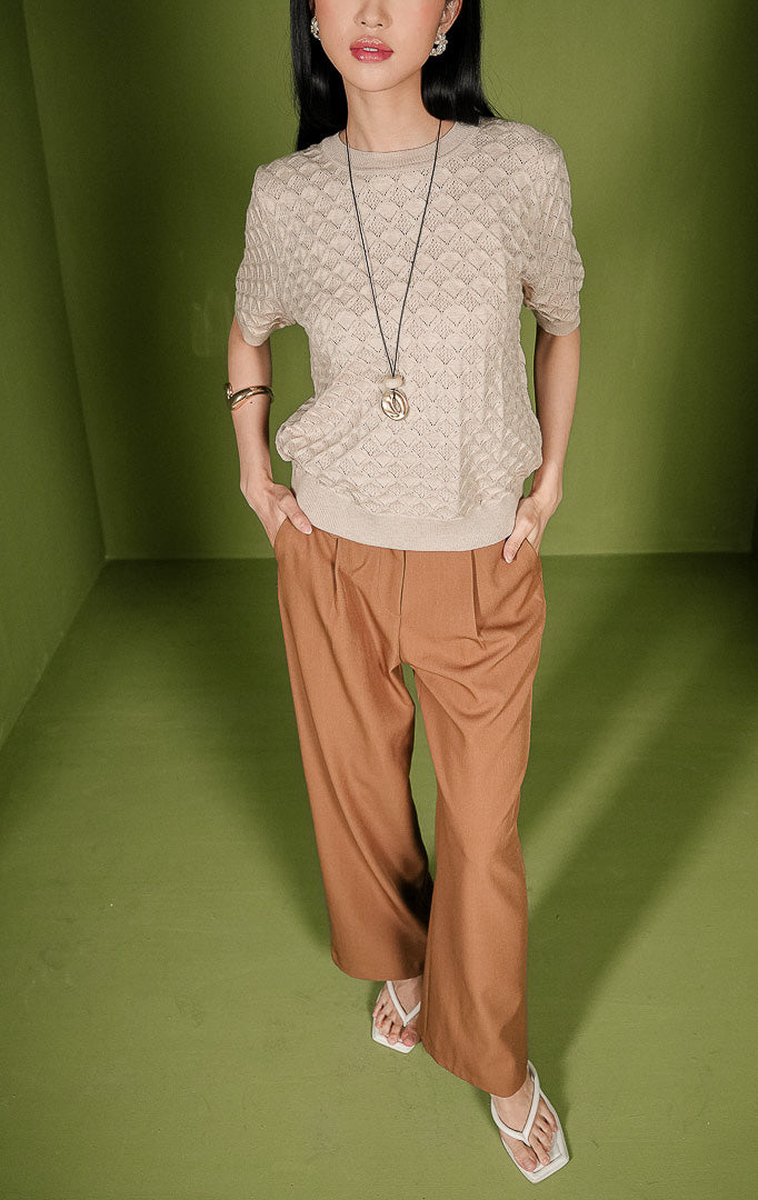 Atasan rajut wanita Harper Top warna beige lengan pendek, dilengkapi kerah bulat (crew neck) beraksen rib, serta dihiasi motif rajutan bertekstur bentuk diamond atau wajik di seluruh permukaannya.
