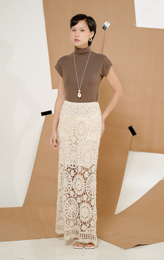 Close up detail tekstur rajutan open-knit dari Harperie Guipure Maxi Skirt Ivory, produk rok panjang wanita warna putih gading dengan lapisan furing pendek di dalam. 