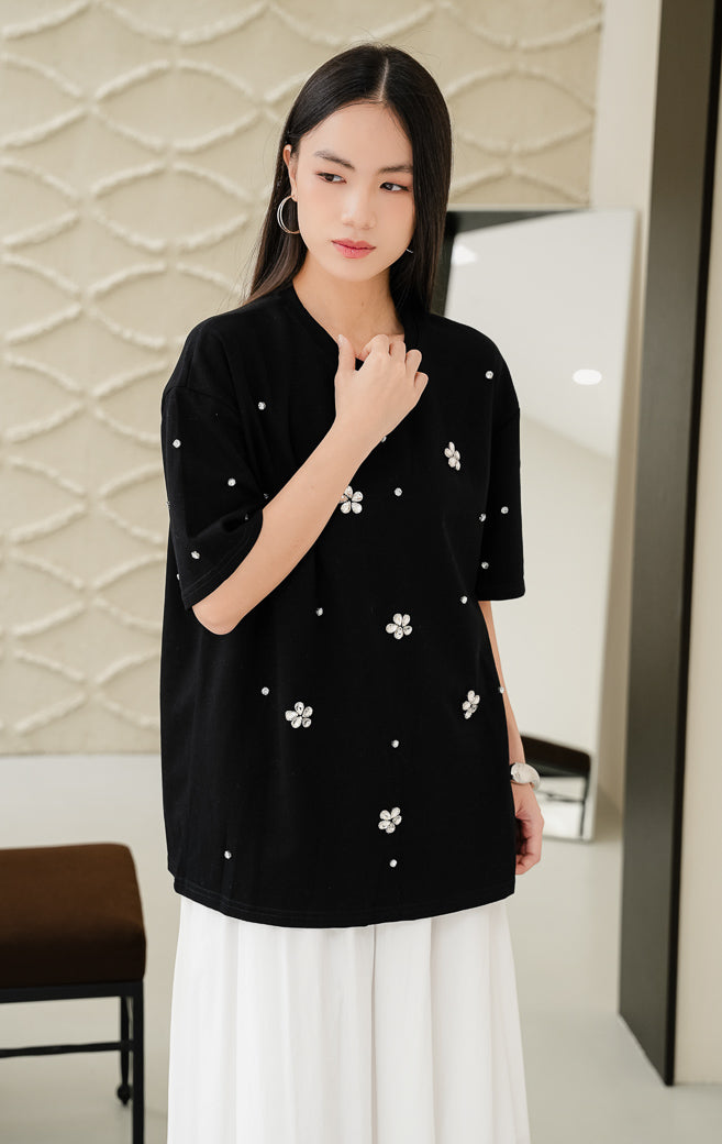 Kaos oversized wanita warna hitam Haru Top dengan detail hiasan kristal floral rhinestone, kerah bulat, dan model santai bergaya streetwear. 

