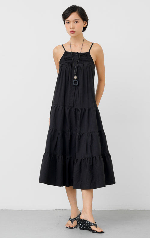 Maxi dress panjang wanita warna hitam Hathaway Dress berbahan katun dengan detail smocked yoke di dada, tali spageti (adjustable straps), dan gaun berundak (tiered silhouette).
