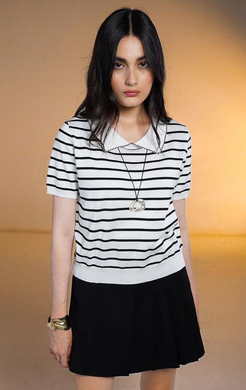 Model wanita memakai Hunter Stripe Knit Top warna hitam motif garis putih, atasan rajut lengan pendek dengan kerah putih tanpa kancing dan detail list hitam