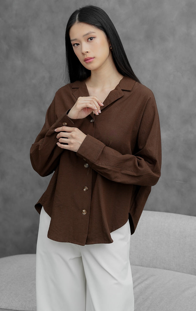 Kemeja wanita lengan panjang warna cokelat tua (dark brown) Ireland Top berbahan linen ringan dengan kerah lapel dan bukaan kancing depan.