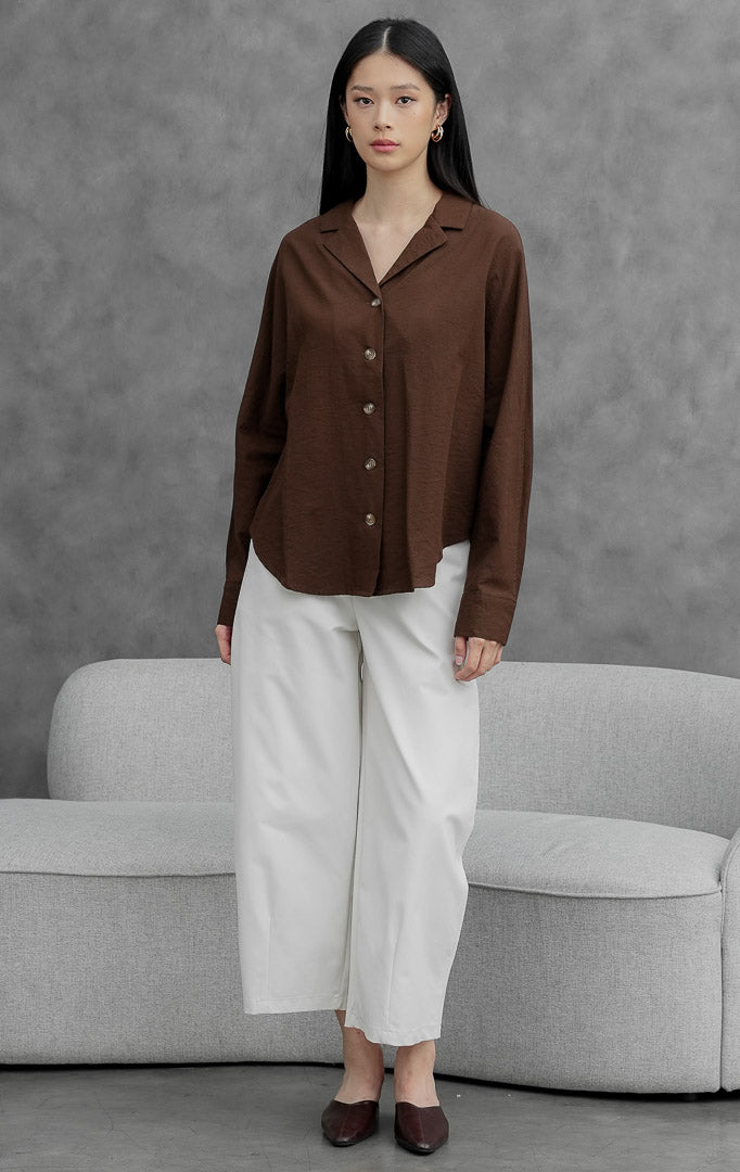 Kemeja wanita lengan panjang warna cokelat tua (dark brown) Ireland Top berbahan linen ringan dengan kerah lapel dan bukaan kancing depan.