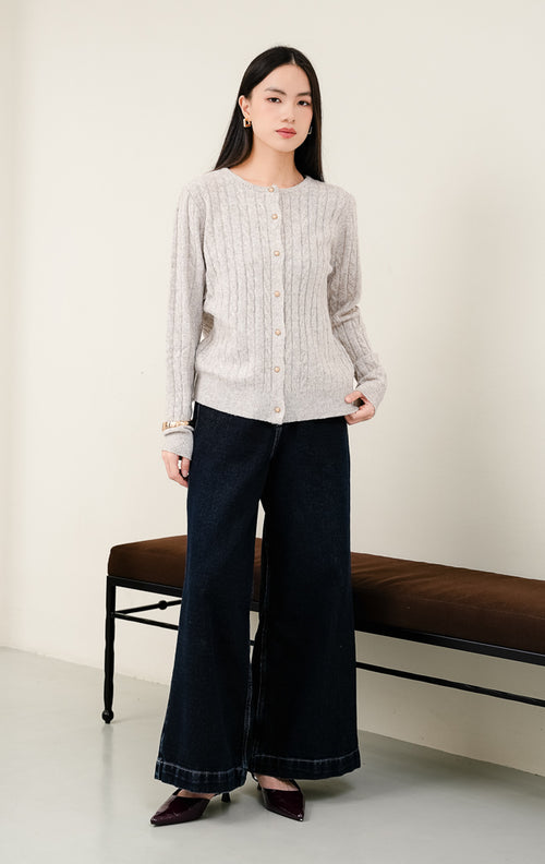 Cardigan rajut wanita Issac Cardigan warna khaki (krem/cokelat muda) motif cable knit tekstur lembut dengan aksen kancing emas (gold button) dan kerah round-neck. 