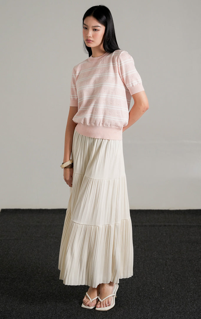 Jourdan Top Pink, atasan rajut lengan pendek motif garis pink dan putih dengan detail tekstur rajutan unik, dipadukan dengan rok panjang putih