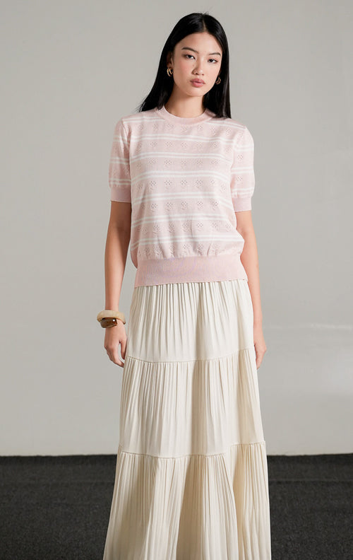 Jourdan Top Pink, atasan rajut lengan pendek motif garis pink dan putih dengan detail tekstur rajutan unik, dipadukan dengan rok panjang putih