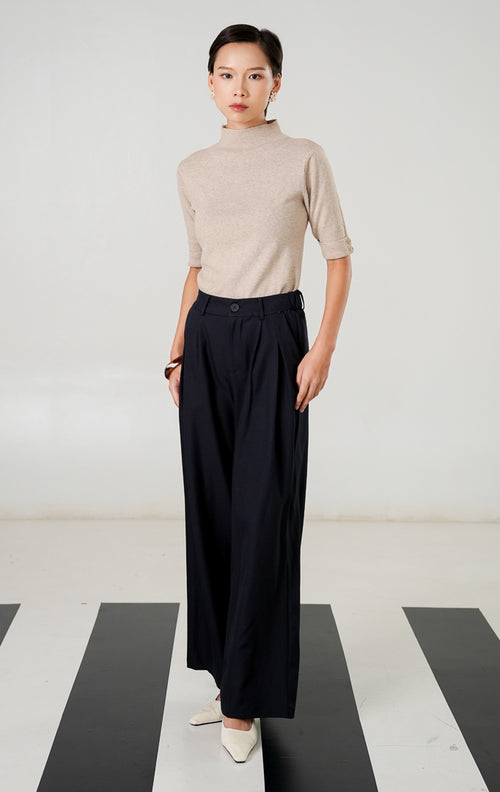 Celana panjang wide leg Kaelith Navy dengan detail lipit (pleats) depan, kancing senada, dan ban pinggang elastis belakang dari This Is April. 