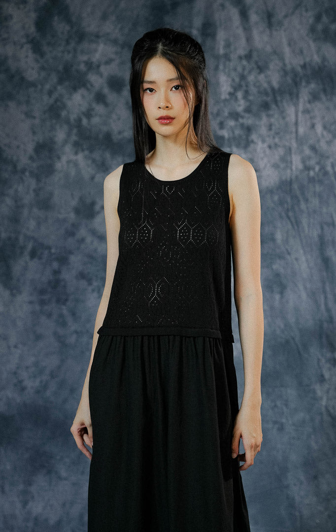 Dress panjang tanpa lengan (maxi dress) wanita Katerinka warna hitam dengan atasan rajut jaring motif geometri dan bagian bawah rok poliester yang flowy.