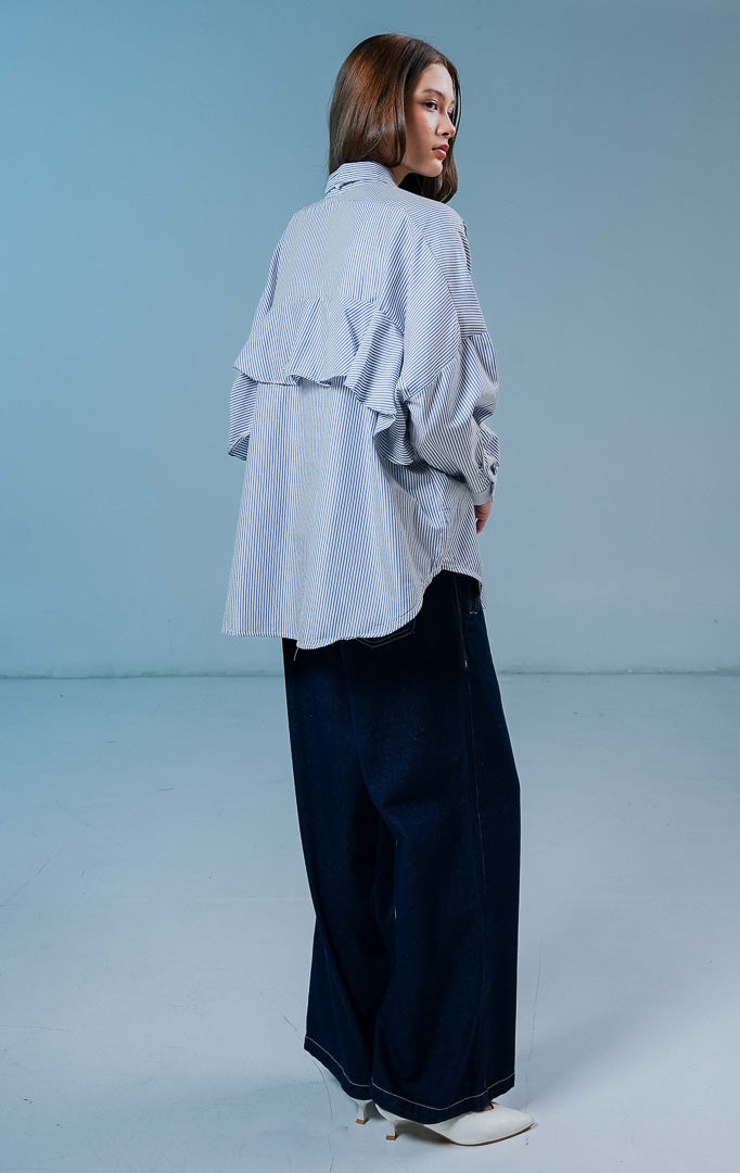 Model wanita mengenakan Dayle Top warna dark blue stripe, kemeja lengan panjang berpotongan longgar dengan motif garis-garis biru dan kancing depan.