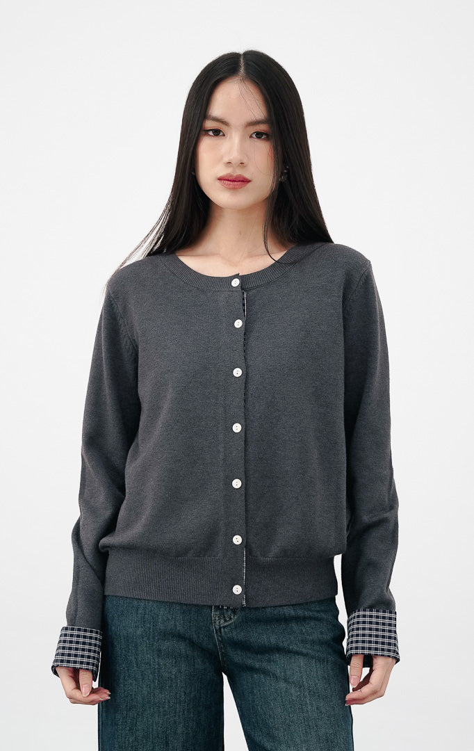 Model mengenakan Kezia Cardigan warna grey, kardigan rajut abu abu dengan kancing depan putih dan detail manset lengan flanel motif kotak kotak