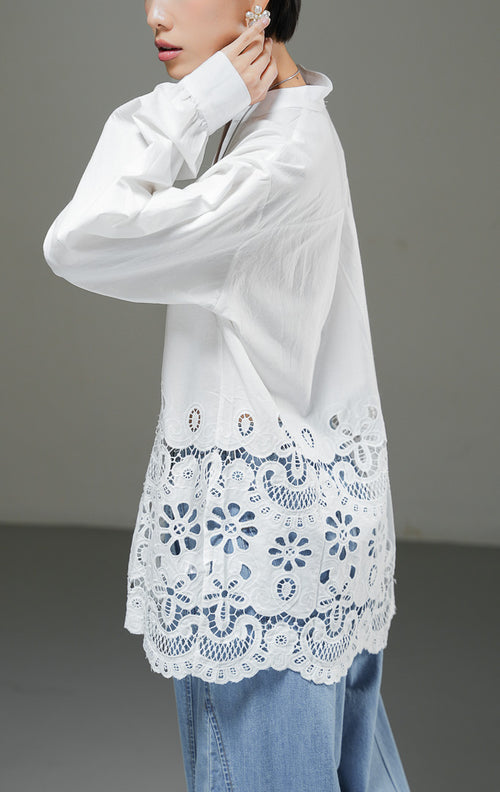 Kemeja wanita Kiraya Top warna putih lengan panjang dengan kerah sanghai V-neck dan detail bordir eyelet renda mewah di bagian bawah hem. 