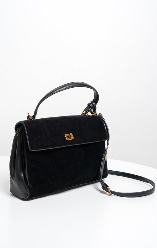 Tas wanita Lalitha warna hitam menampilkan kombinasi bahan kulit sintetis dan suede bertekstur lembut, penutup flap dengan kunci putar (twist lock) warna emas, lengkap dengan tali jinjing pendek (handbag) serta tali panjang (sling bag).