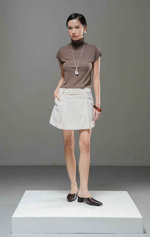 Rok celana wanita Leuana Skort warna ivory krem berbahan corduroy dengan detail pleat lipatan depan dan bagian celana tersembunyi di dalam.
