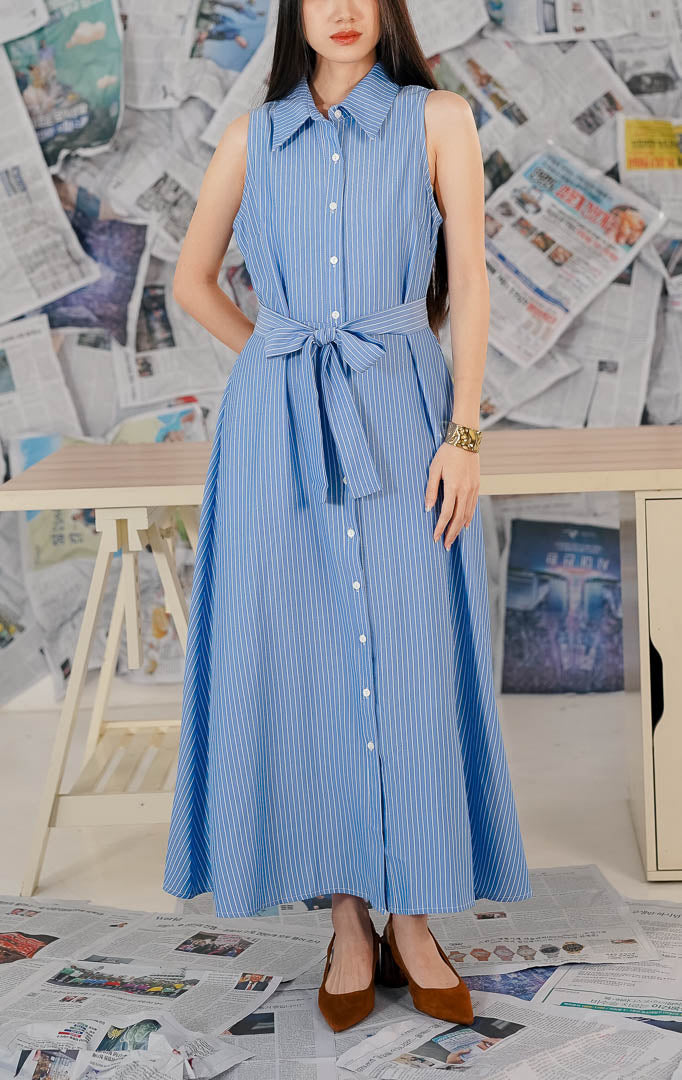 Model wanita memakai This Is April Lexington Dress Blue, dress warna biru [muda/tua] dengan detail [kerah kemeja/tali pinggang] dan potongan [lengan panjang/pendek] yang elegan