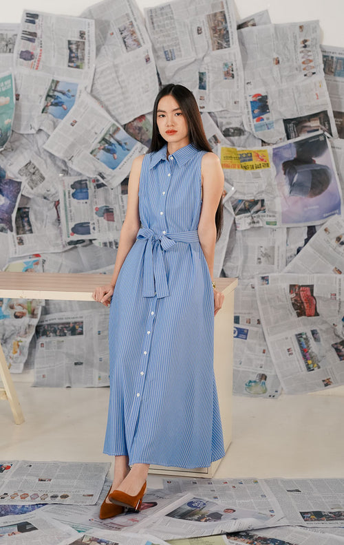Model wanita memakai This Is April Lexington Dress Blue, dress warna biru [muda/tua] dengan detail [kerah kemeja/tali pinggang] dan potongan [lengan panjang/pendek] yang elegan.1