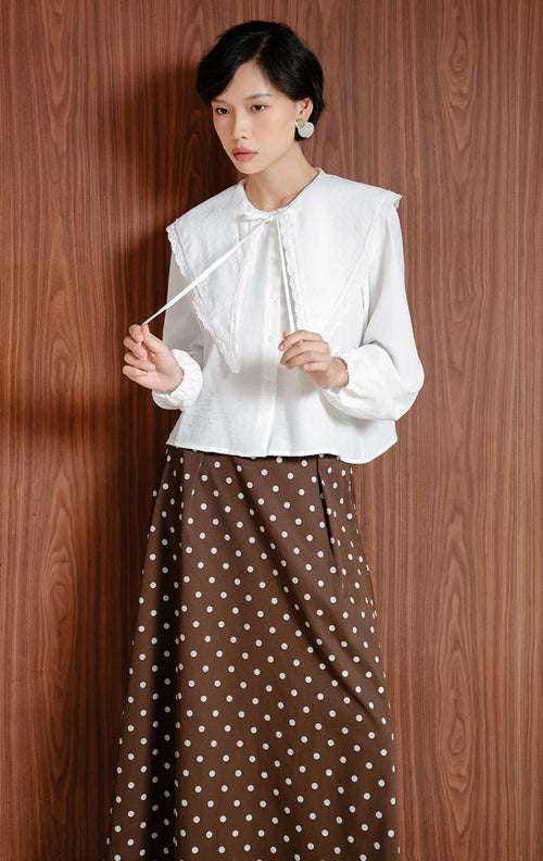 Atasan wanita warna putih Linara Top berbahan katun berstruktur dengan detail kerah scalloped Peter Pan untuk tampilan chic, classic, dan office look.