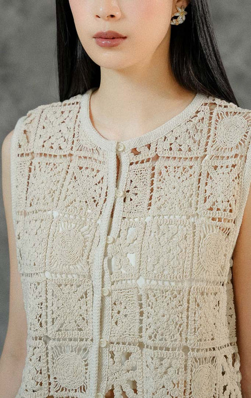 Rompi rajut tanpa lengan wanita Lionella warna ivory berbahan premium crochet dengan cutting round neck klasik dan deretan kancing hidup di depan.