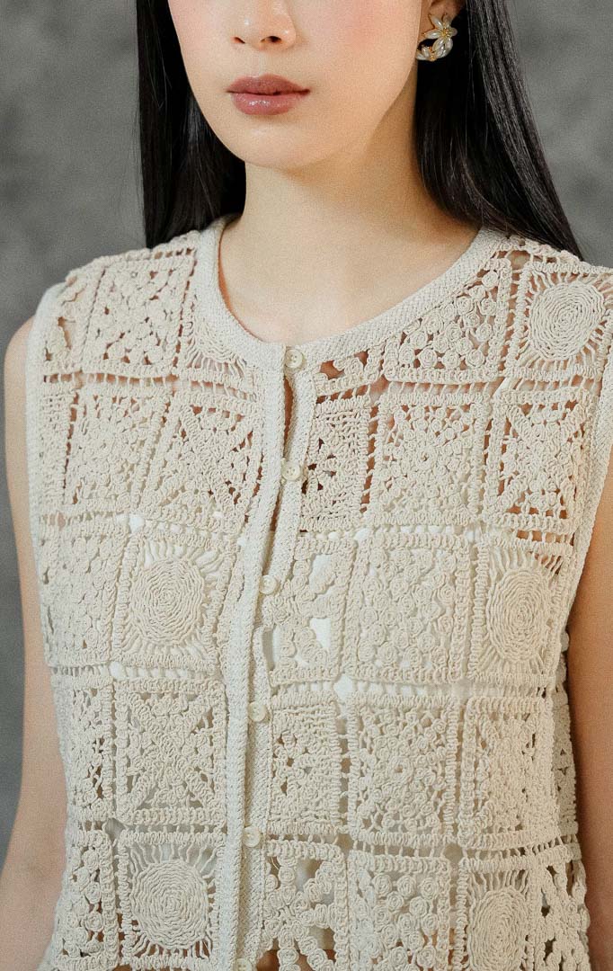 Rompi rajut tanpa lengan wanita Lionella warna ivory berbahan premium crochet dengan cutting round neck klasik dan deretan kancing hidup di depan.