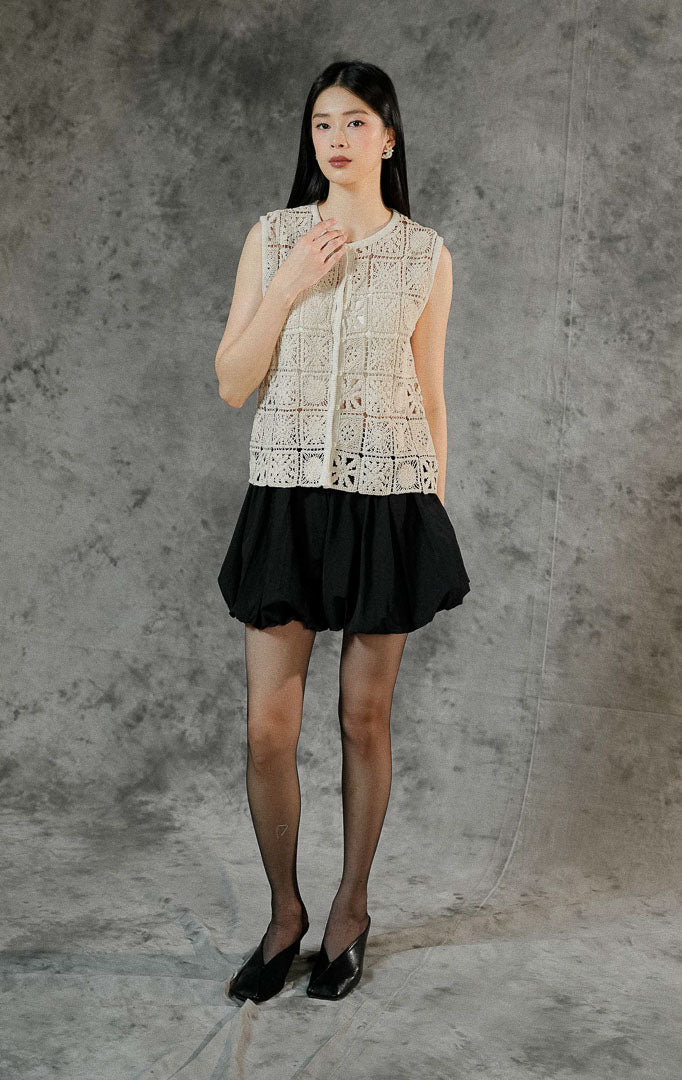 Rompi rajut tanpa lengan wanita Lionella warna ivory berbahan premium crochet dengan cutting round neck klasik dan deretan kancing hidup di depan.