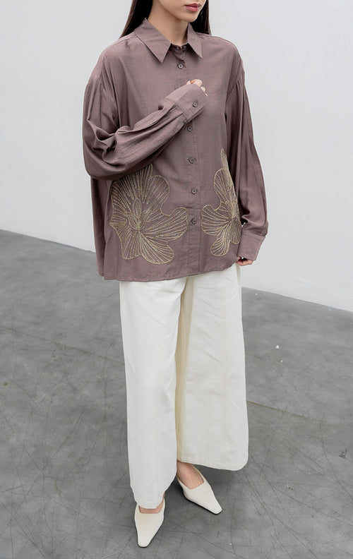 Kemeja lengan panjang wanita warna cokelat keabu-abuan (taupe) Loletta Top berbahan campuran linen-poliester (linen-polyester blend) dengan aksen bordir lurex berkilau (shimmer) di bagian bawah dan bukaan kancing depan.
