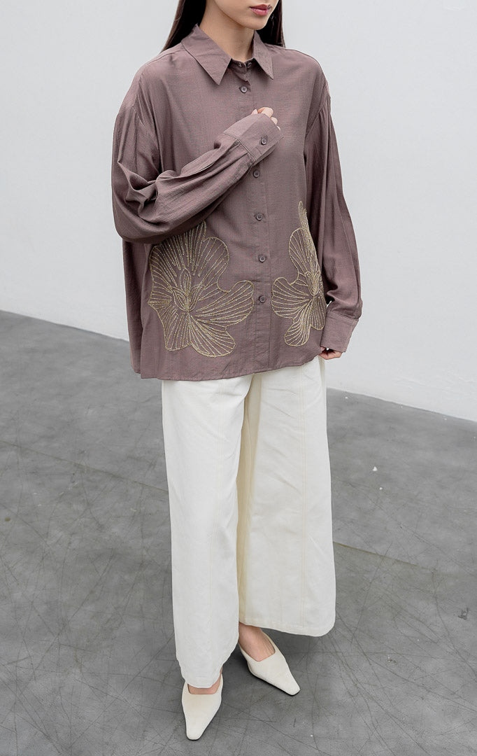 Kemeja lengan panjang wanita warna cokelat keabu-abuan (taupe) Loletta Top berbahan campuran linen-poliester (linen-polyester blend) dengan aksen bordir lurex berkilau (shimmer) di bagian bawah dan bukaan kancing depan.
