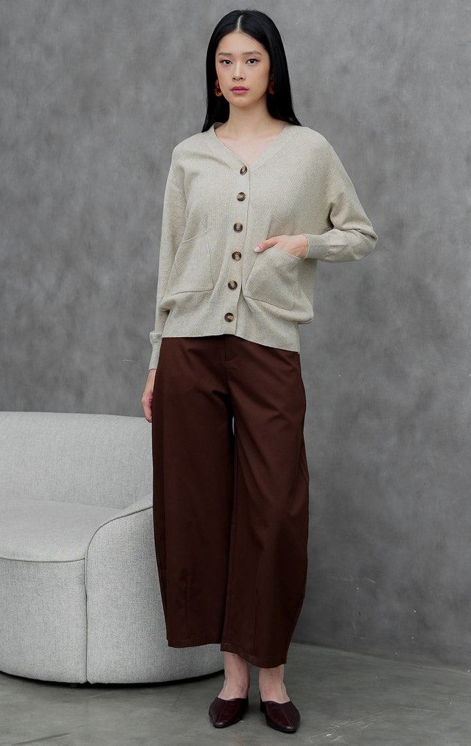Kardigan rajut wanita model longgar (oversized) warna cokelat muda (khaki) Lumora Cardigan dengan kerah V (V-neck), saku fungsional depan, dan kancing.