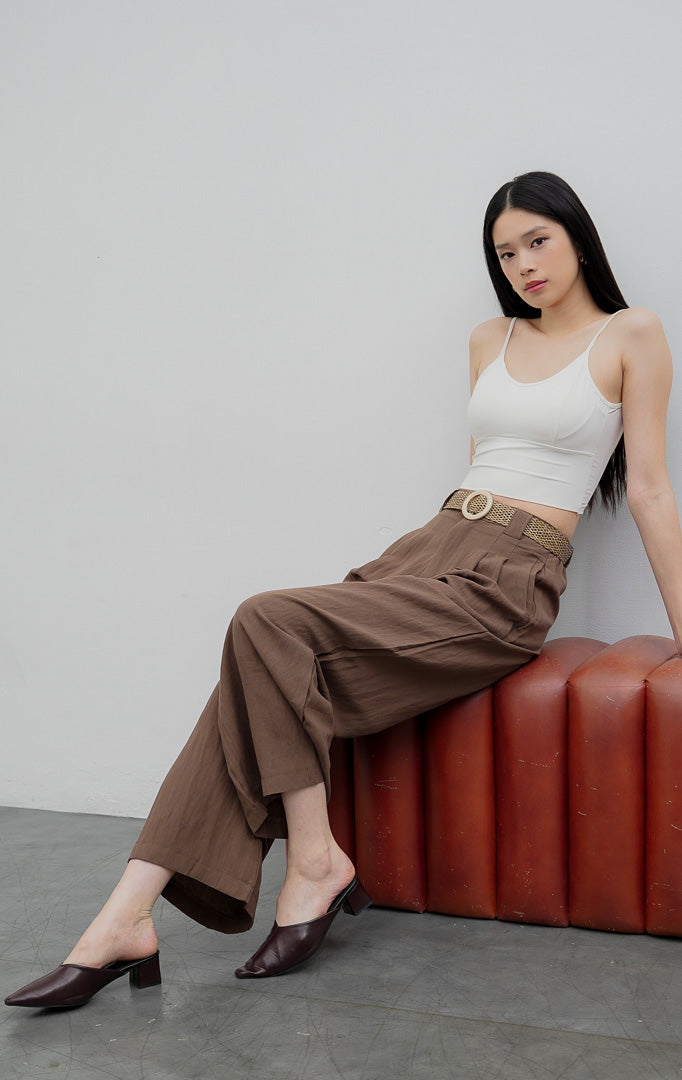 Celana kulot panjang wanita model longgar (wide-leg pants) warna cokelat (brown) Maeve Pants berbahan campuran katun-linen (cotton-linen blend) dengan aksen lipit depan (front pleats), kancing depan, dan saku samping.