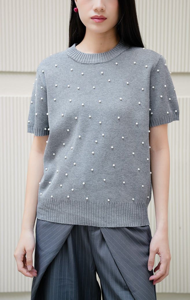 Atasan rajut wanita warna abu-abu Maple Top dengan aksen hiasan mutiara pearl studded, kerah bulat crew neck, dan lengan pendek yang elegan. 