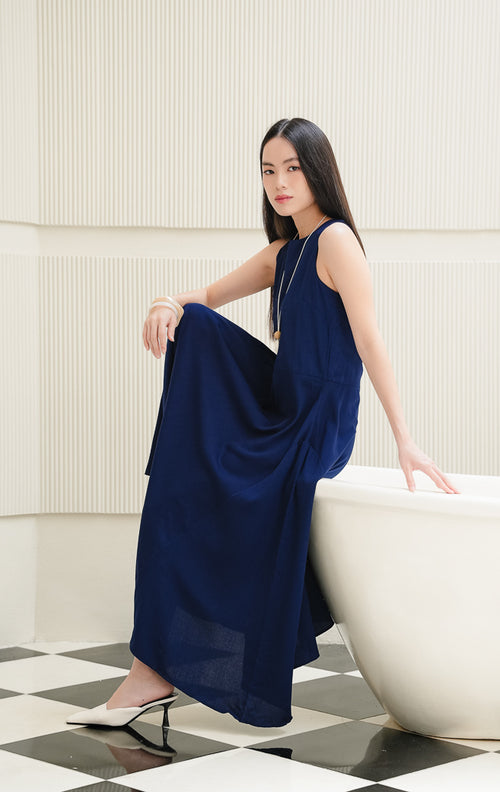 Long dress wanita tanpa lengan (sleeveless) warna navy Marcheta Dress dengan siluet A-line, kerah bulat (round-neck), dan resleting belakang. 