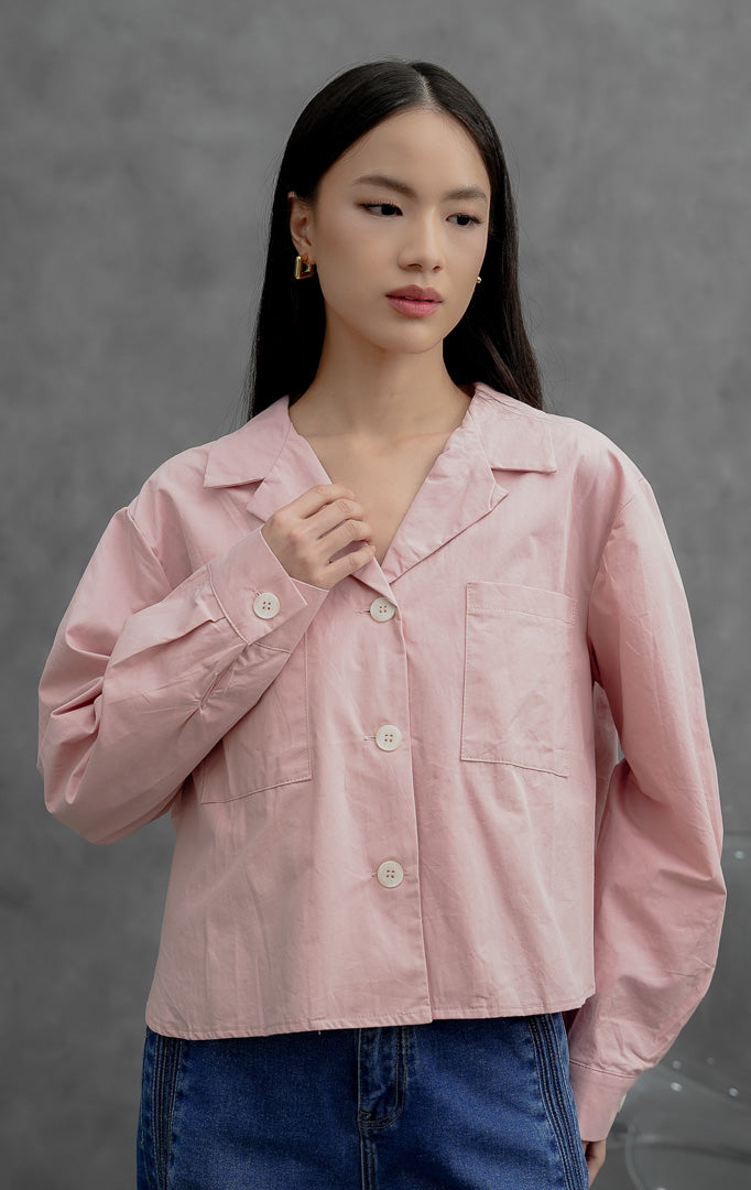Atasan wanita model cropped blazer lengan panjang warna merah muda (pink) Meadow Top berbahan katun terstruktur dengan kerah Cuban collar, bukaan kancing depan, dan saku saku dada fungsional.