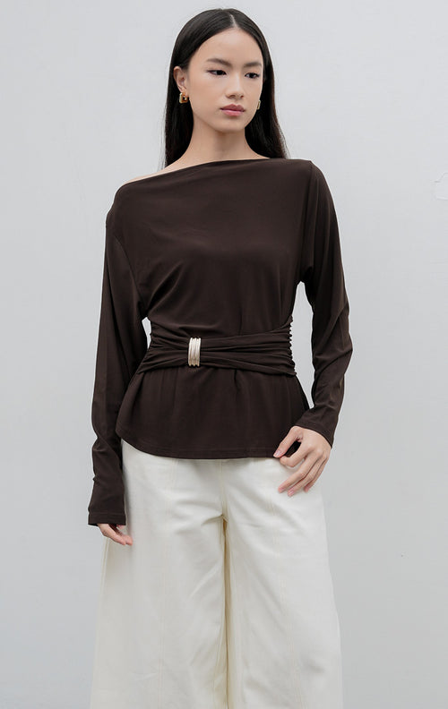 Atasan lengan panjang wanita warna cokelat tua (dark brown) Mezza Top berbahan jersey stretch dengan aksen draped, kerut pinggang (gathered waist), dan hiasan bros (brooch).