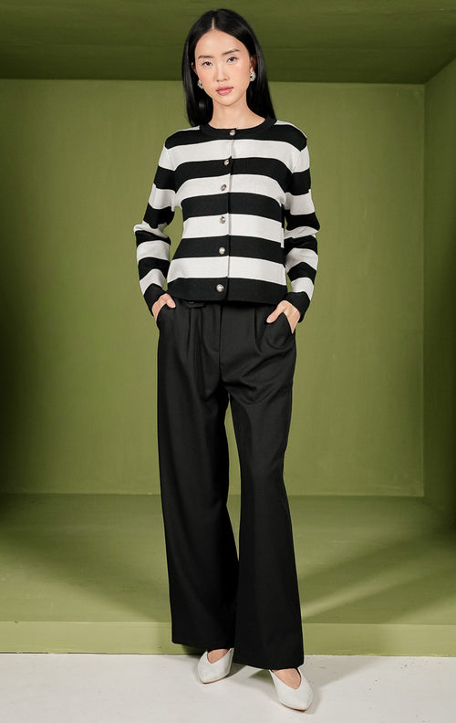 Atasan rajut wanita Mia Top lengan panjang dengan motif garis horizontal berwarna hitam dan putih, dilengkapi kerah bulat (crew neck) dan deretan kancing berwarna emas di bagian depan. 