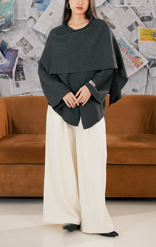 "Wanita mengenakan Moet Sweater warna dark grey, atasan rajut lengan panjang dengan kancing depan dan desain kerah unik yang menyerupai syal draperi (draped scarf neck)