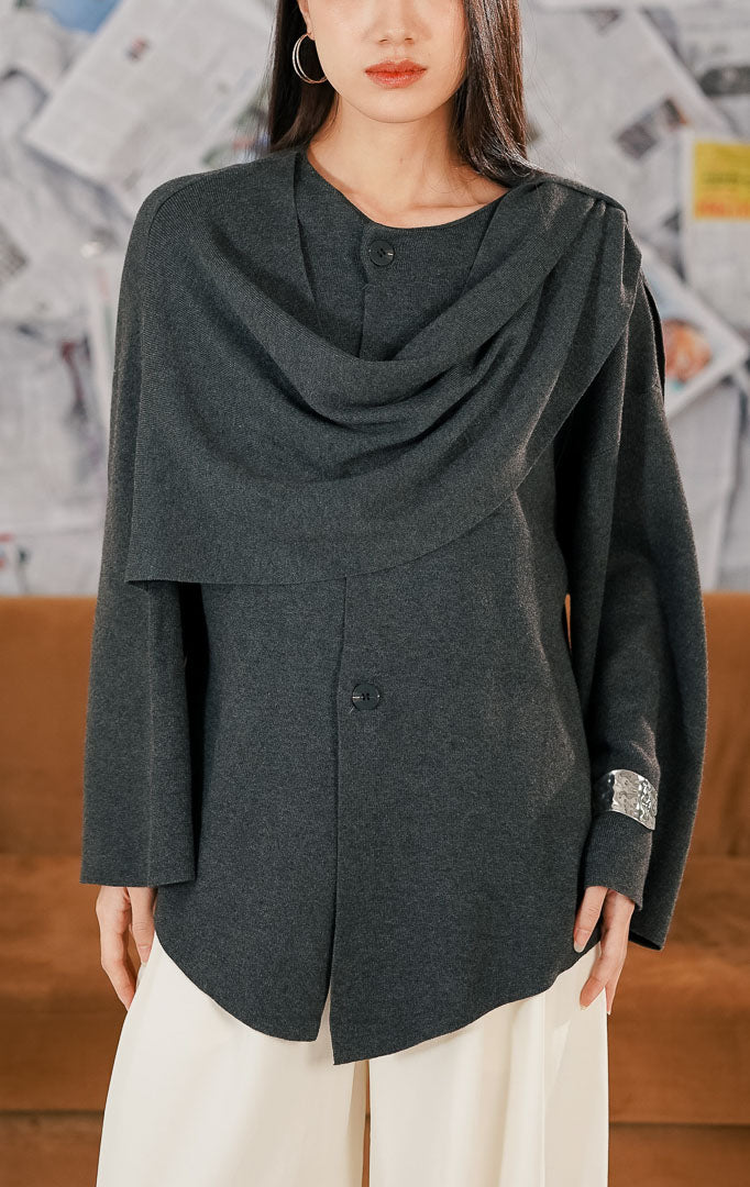 Wanita mengenakan Moet Sweater warna dark grey, atasan rajut lengan panjang dengan kancing depan dan desain kerah unik yang menyerupai syal draperi (draped scarf neck)1