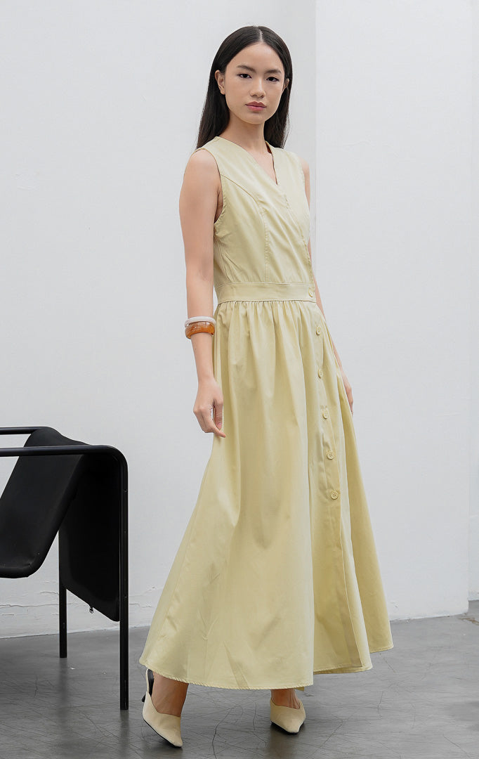 Gaun terusan wanita tanpa lengan (sleeveless dress) warna kuning lembut (butter yellow) Monrow Dress berpotongan A-line berbahan campuran katun-poliester dengan kerah V, detail panelled bodice, dan bukaan kancing depan.
